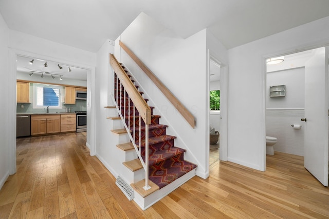 8121 Blind Brook Ct, Columbus, OH 43235 - staircase featuring hardwood / wood-style floors, wainscoting, and tile walls