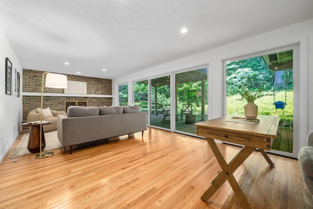 8121 Blind Brook Ct, Columbus, OH 43235 - living room with plenty of natural light, brick wall, light wood-style floors, a textured ceiling, and recessed lighting