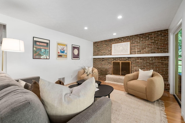8121 Blind Brook Ct, Columbus, OH 43235 - living room featuring wood finished floors, a fireplace, recessed lighting, and brick wall