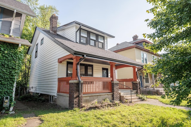 463 E Woodrow Ave, Columbus, OH 43207 - view of front facade with covered porch, a chimney, a front lawn, and roof with shingles