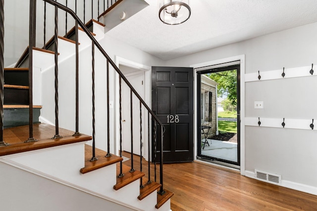 128 S Kellner Rd, Columbus, OH 43209 - foyer with stairway, wood finished floors, a textured ceiling, and baseboards