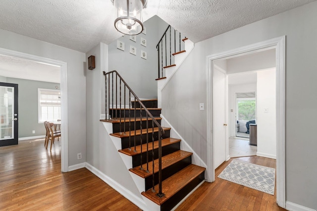 128 S Kellner Rd, Columbus, OH 43209 - staircase featuring wood-type flooring, a textured ceiling, and baseboards