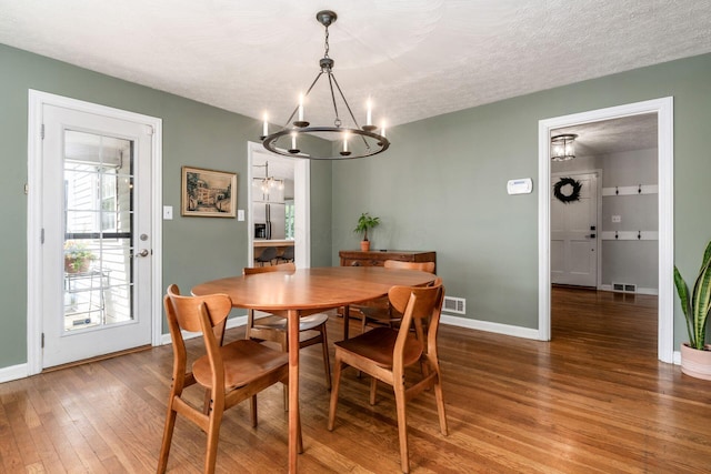 128 S Kellner Rd, Columbus, OH 43209 - dining space featuring a chandelier, wood finished floors, baseboards, and a textured ceiling