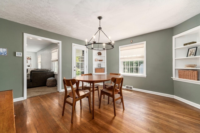 128 S Kellner Rd, Columbus, OH 43209 - dining space with a chandelier, wood-type flooring, built in features, baseboards, and plenty of natural light