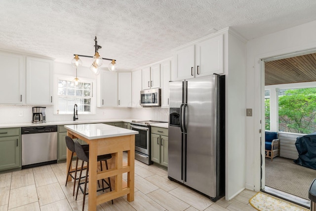 128 S Kellner Rd, Columbus, OH 43209 - kitchen featuring appliances with stainless steel finishes, healthy amount of natural light, light countertops, tasteful backsplash, and a textured ceiling