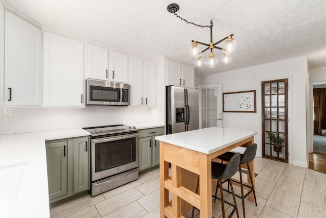 128 S Kellner Rd, Columbus, OH 43209 - kitchen with stainless steel appliances, tasteful backsplash, light countertops, a chandelier, and a textured ceiling