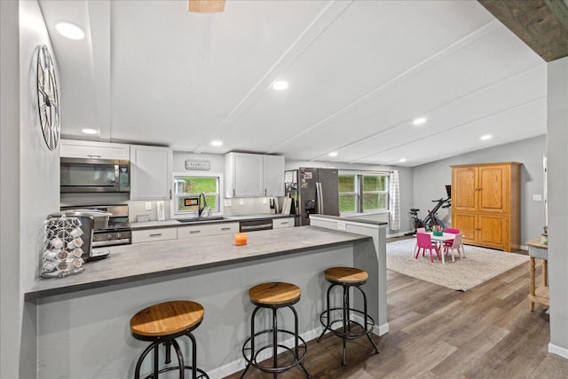 5895 Swartz Mill Rd SE, Sugar Grove, OH 43155 - kitchen with appliances with stainless steel finishes, a sink, a breakfast bar, wood finished floors, and recessed lighting