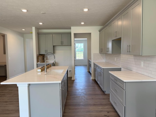 3323 Tender Ave Lot 7165, Powell, OH 43065 - kitchen featuring gray cabinetry, dark wood finished floors, a center island with sink, recessed lighting, and a textured ceiling