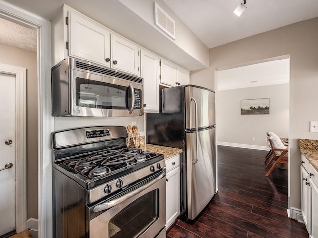 3579 Aaron Dr, Columbus, OH 43228 - kitchen featuring appliances with stainless steel finishes, white cabinetry, dark wood finished floors, and light stone counters