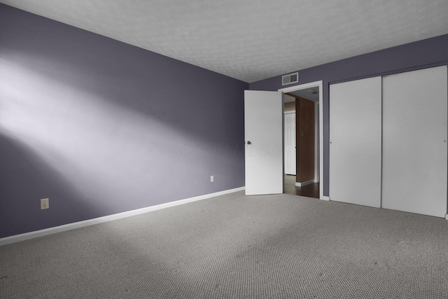 1530 Slade Ave Unit 103, Columbus, OH 43235 - unfurnished bedroom featuring a textured ceiling, a closet, baseboards, and carpet