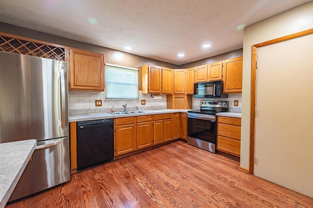 5102 Avalon Ave, Columbus, OH 43229 - kitchen with black appliances, light countertops, wood finished floors, recessed lighting, and tasteful backsplash