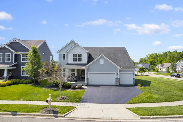 185 Saffron Dr, Sunbury, OH 43074 - craftsman-style home with board and batten siding, a front yard, an attached garage, and stone siding