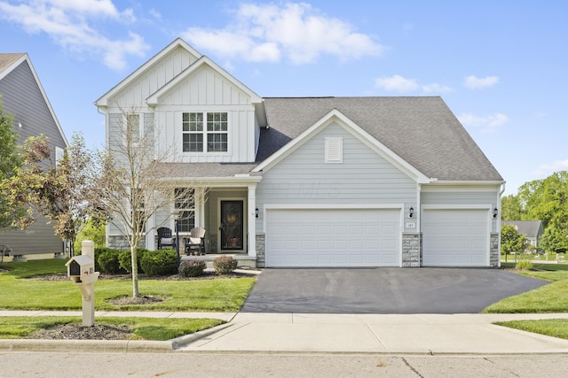 185 Saffron Dr, Sunbury, OH 43074 - view of front facade featuring board and batten siding, driveway, stone siding, and a garage