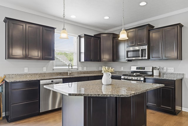 185 Saffron Dr, Sunbury, OH 43074 - kitchen featuring stainless steel appliances, a sink, light wood finished floors, dark brown cabinets, and a kitchen island