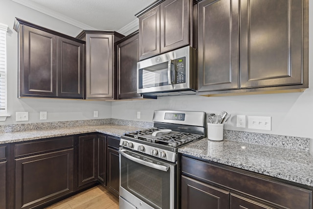 185 Saffron Dr, Sunbury, OH 43074 - kitchen with stainless steel appliances, crown molding, light stone countertops, dark brown cabinets, and light wood-type flooring