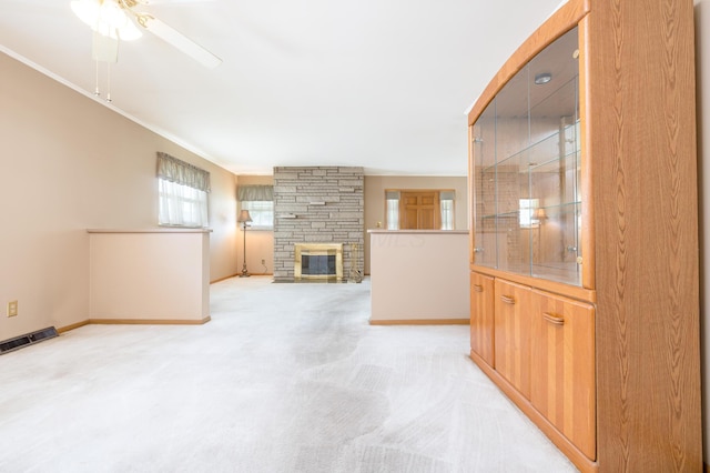 803 Wiltshire Rd, Columbus, OH 43204 - unfurnished living room with a ceiling fan, light colored carpet, baseboards, ornamental molding, and a stone fireplace