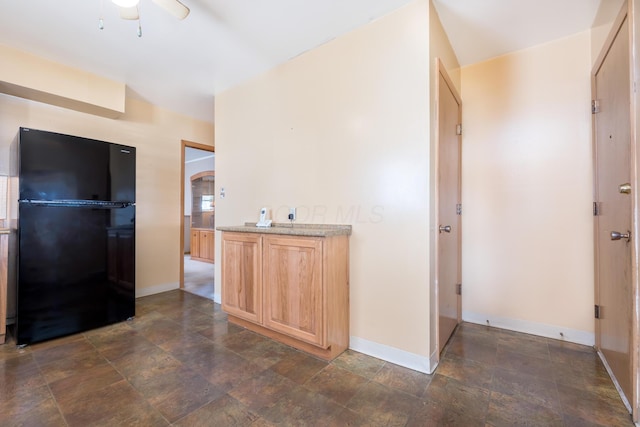 803 Wiltshire Rd, Columbus, OH 43204 - kitchen with freestanding refrigerator, light brown cabinets, stone finish floors, and baseboards