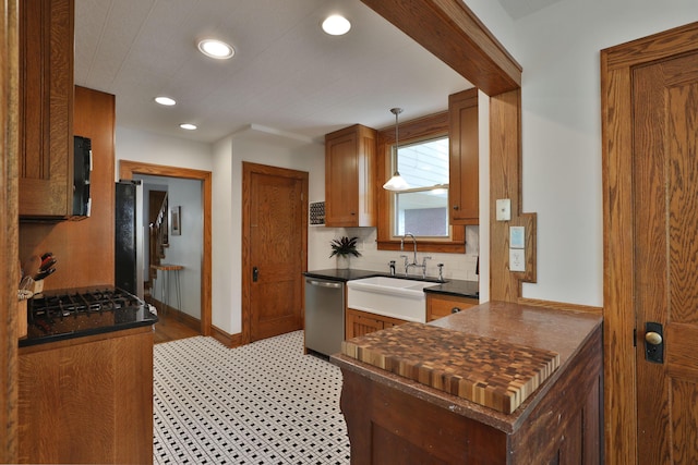 203 Winthrop Rd, Columbus, OH 43214 - kitchen featuring dishwasher, a sink, dark countertops, brown cabinets, and recessed lighting