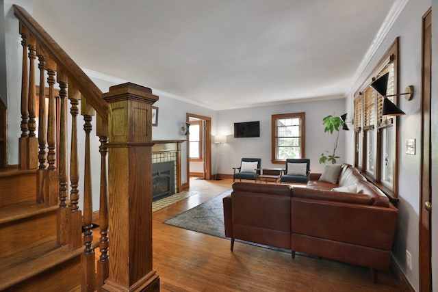 203 Winthrop Rd, Columbus, OH 43214 - living area with crown molding, wood finished floors, a tiled fireplace, baseboards, and stairs
