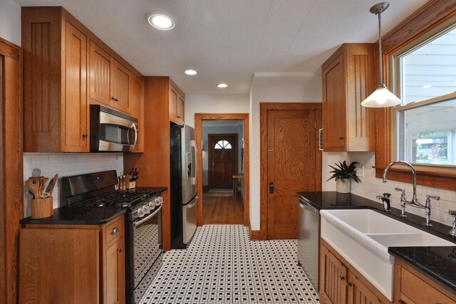 203 Winthrop Rd, Columbus, OH 43214 - kitchen featuring appliances with stainless steel finishes, brown cabinets, a sink, recessed lighting, and backsplash