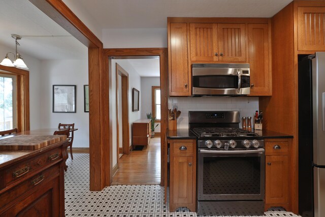 203 Winthrop Rd, Columbus, OH 43214 - kitchen featuring appliances with stainless steel finishes, brown cabinetry, and dark countertops