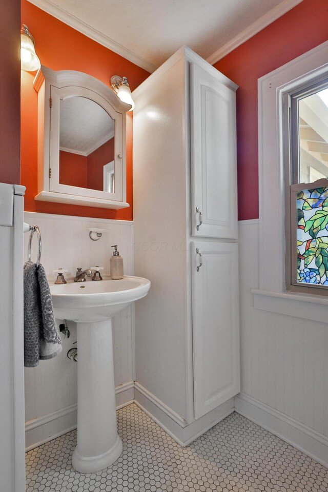 203 Winthrop Rd, Columbus, OH 43214 - bathroom featuring a wainscoted wall, crown molding, tile patterned flooring, a sink, and baseboards