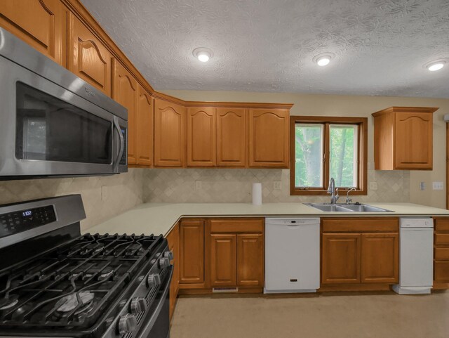 8587 Blacks Rd, Pataskala, OH 43062 - kitchen with appliances with stainless steel finishes, a sink, backsplash, light countertops, and a textured ceiling