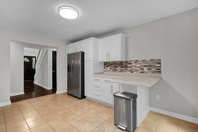 6233 Coonpath Rd NW, Carroll, OH 43112 - kitchen with stainless steel fridge, light countertops, decorative backsplash, white cabinetry, and light tile patterned flooring
