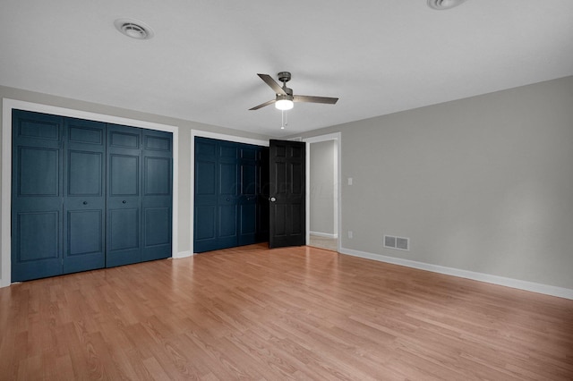 6233 Coonpath Rd NW, Carroll, OH 43112 - unfurnished bedroom featuring light wood-style floors, multiple closets, and ceiling fan