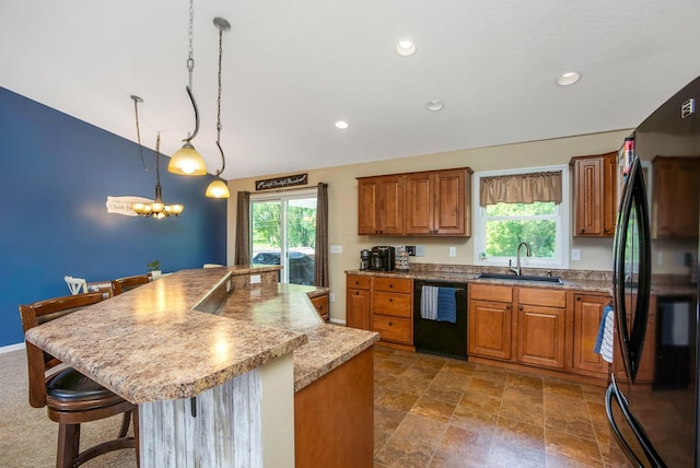 765 Huntley Ave, Logan, OH 43138 - kitchen with black appliances, a sink, brown cabinets, vaulted ceiling, and a breakfast bar area