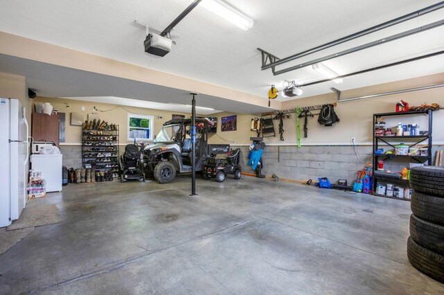 765 Huntley Ave, Logan, OH 43138 - garage featuring washer / dryer, a garage door opener, and freestanding refrigerator