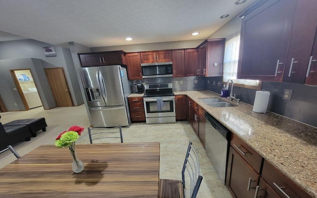 3230 Saint Bernard Cir, Columbus, OH 43232 - kitchen featuring stainless steel appliances, a sink, reddish brown cabinets, light stone countertops, and a textured ceiling