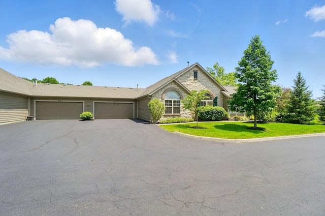 4298 Bridgeside Pl, New Albany, OH 43054 - view of front of property featuring an attached garage, driveway, a front yard, and stone siding
