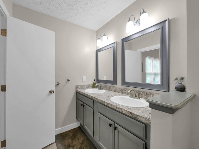 2908 Torrey Pines Dr, Pickerington, OH 43147 - bathroom featuring double vanity, a textured ceiling, and baseboards