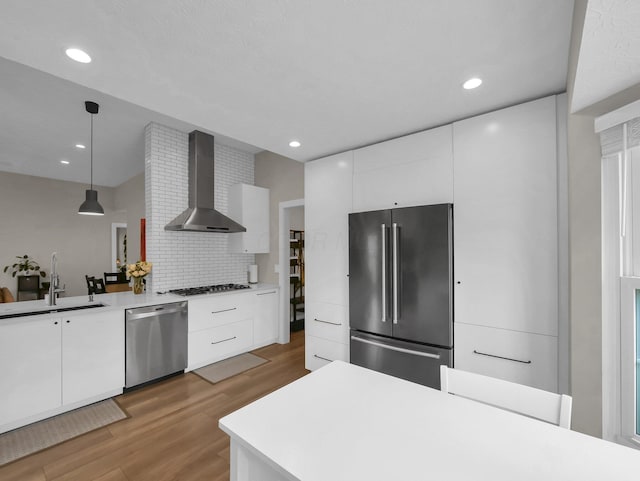 2908 Torrey Pines Dr, Pickerington, OH 43147 - kitchen with appliances with stainless steel finishes, wall chimney exhaust hood, a sink, modern cabinets, and light wood-style flooring