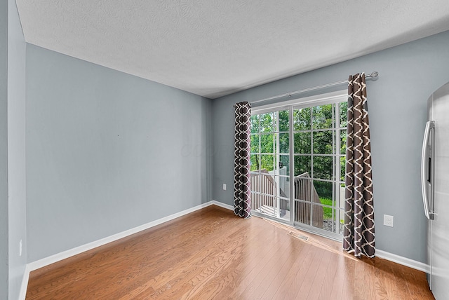 5801 Bridgehampton Dr, New Albany, OH 43054 - spare room with wood finished floors, a textured ceiling, and arched walkways