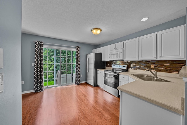 5801 Bridgehampton Dr, New Albany, OH 43054 - kitchen with stainless steel appliances, light wood-style flooring, a textured ceiling, white cabinetry, and backsplash