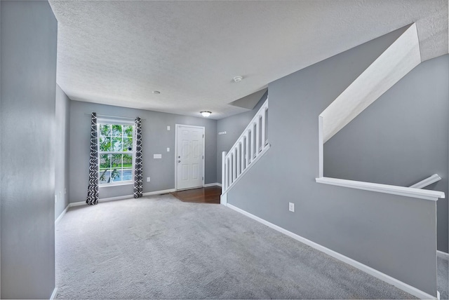 5801 Bridgehampton Dr, New Albany, OH 43054 - unfurnished living room featuring a textured ceiling, stairs, and carpet flooring
