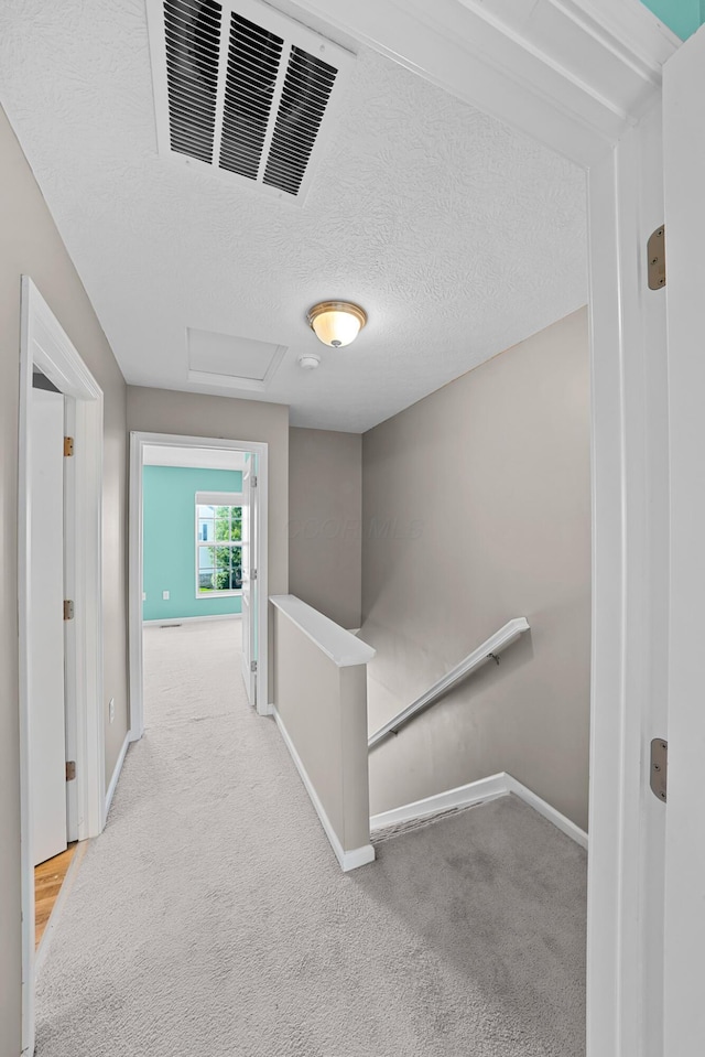 5801 Bridgehampton Dr, New Albany, OH 43054 - hall featuring an upstairs landing, attic access, carpet floors, and a textured ceiling