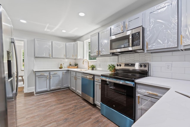 1271 Moundview Ave, Columbus, OH 43207 - kitchen with appliances with stainless steel finishes, gray cabinetry, a sink, recessed lighting, and dark wood finished floors