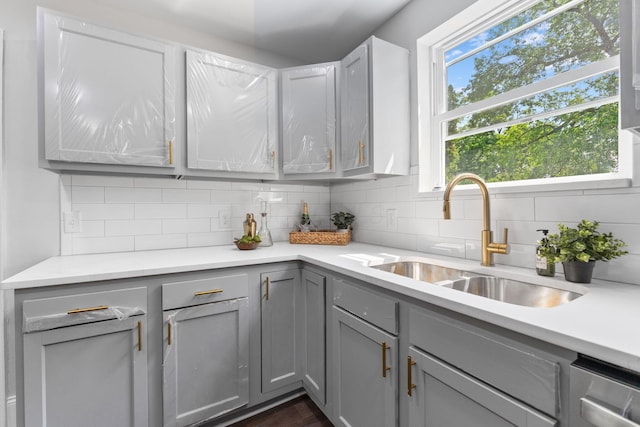 1271 Moundview Ave, Columbus, OH 43207 - kitchen with gray cabinets, a sink, light countertops, and tasteful backsplash