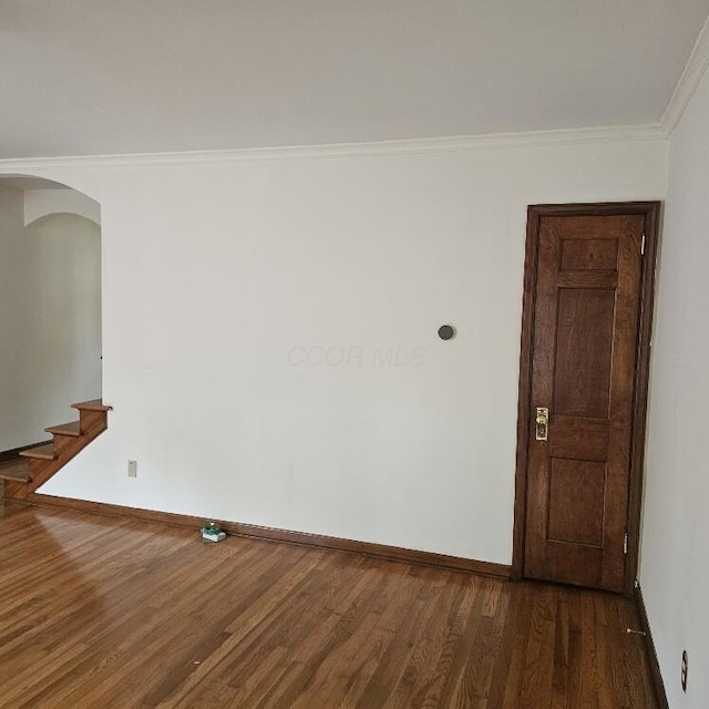 2325 E Livingston Ave, Columbus, OH 43209 - unfurnished room with arched walkways, wood finished floors, baseboards, crown molding, and stairs