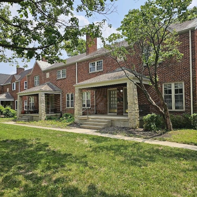 2325 E Livingston Ave, Columbus, OH 43209 - back of property with a porch, a lawn, a chimney, and brick siding