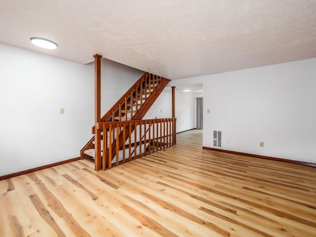 873 Soramill Ln Unit 4B, Columbus, OH 43085 - spare room with wood finished floors, baseboards, stairway, and a textured ceiling