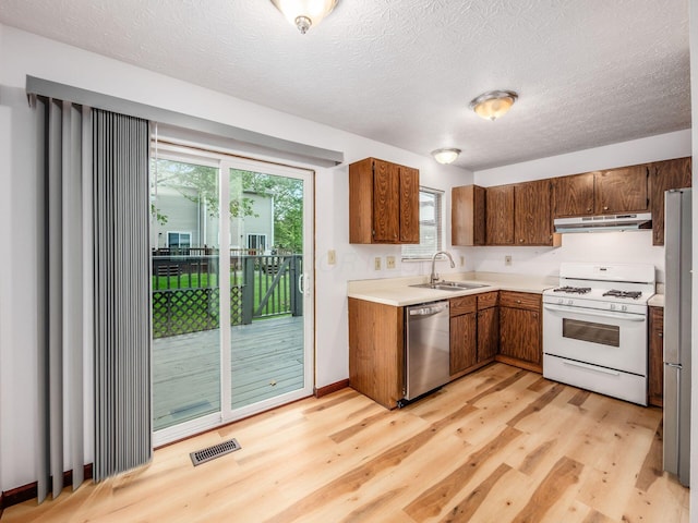 873 Soramill Ln Unit 4B, Columbus, OH 43085 - kitchen featuring dishwasher, white range with gas stovetop, under cabinet range hood, a sink, and light wood finished floors