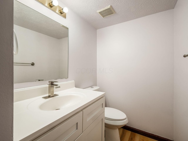 873 Soramill Ln Unit 4B, Columbus, OH 43085 - half bathroom with wood finished floors, toilet, vanity, and a textured ceiling