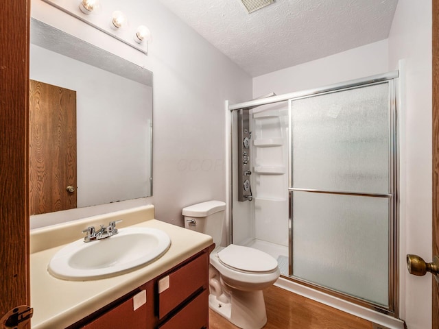 873 Soramill Ln Unit 4B, Columbus, OH 43085 - full bath featuring vanity, a stall shower, toilet, wood finished floors, and a textured ceiling