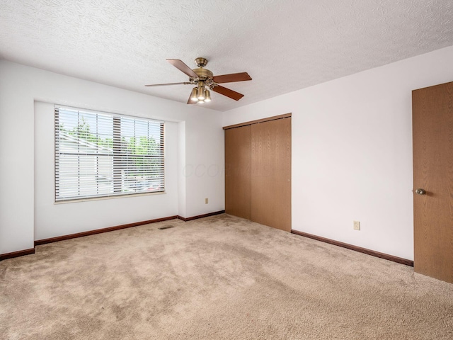 873 Soramill Ln Unit 4B, Columbus, OH 43085 - unfurnished bedroom with carpet flooring, a closet, a textured ceiling, a ceiling fan, and baseboards