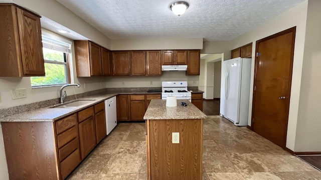 624 Village Park Dr, Powell, OH 43065 - kitchen featuring white appliances, under cabinet range hood, a kitchen island, a textured ceiling, and light stone counters