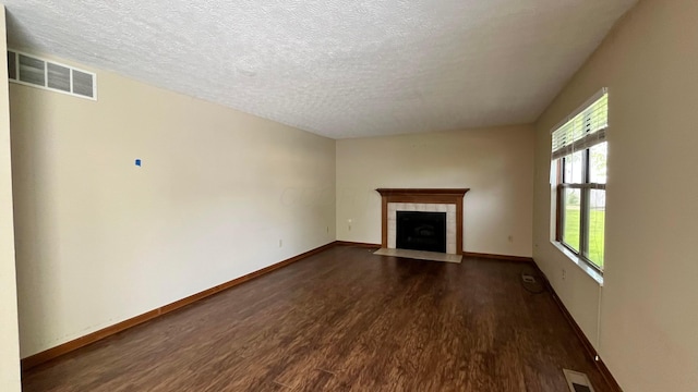 624 Village Park Dr, Powell, OH 43065 - unfurnished living room featuring dark wood-style floors, a tile fireplace, and a textured ceiling